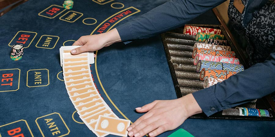 a dealer spreading a deck of playing cards on a casino table